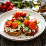 Breakfast - cottage cheese, bread and vegetables on wooden table
